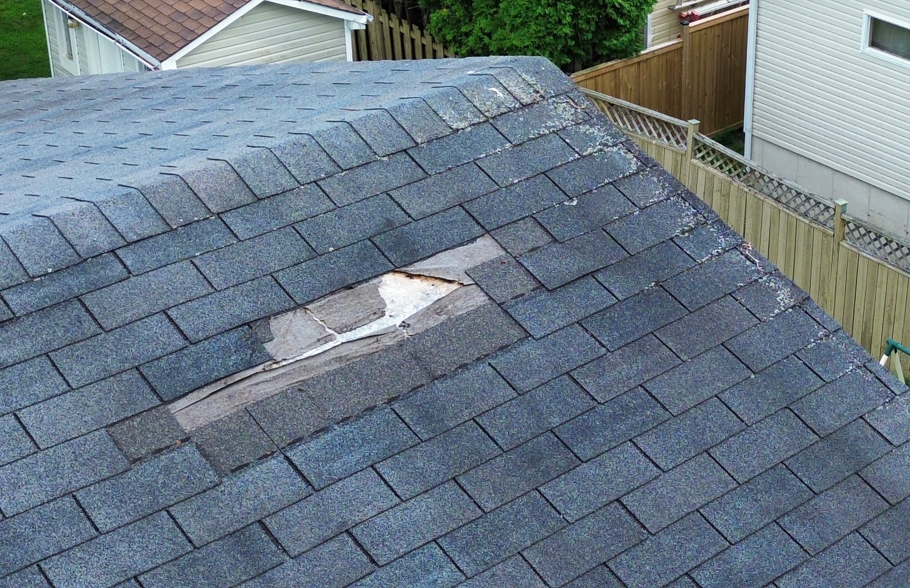 Close-up drone photo of missing asphalt shingles exposing roof underlayment during a home inspection in Orléans, Ottawa