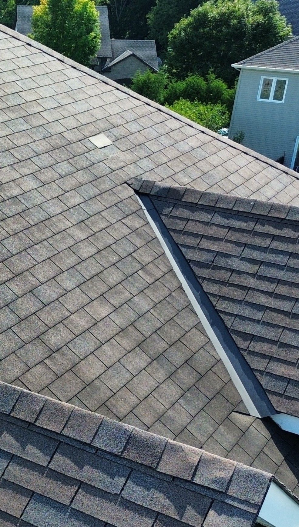 Close-up drone photo of a missing and loose shingle on a roof valley during an Ottawa home inspection
